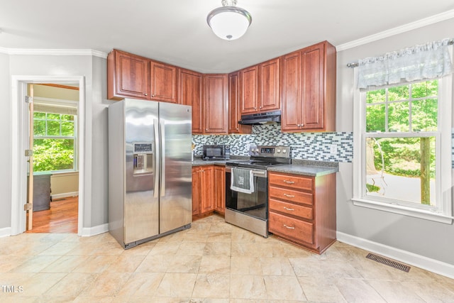 2555 Winding Creek Ln, Franklinton, NC 27525 - kitchen featuring appliances with stainless steel finishes, under cabinet range hood, crown molding, tasteful backsplash, and dark countertops