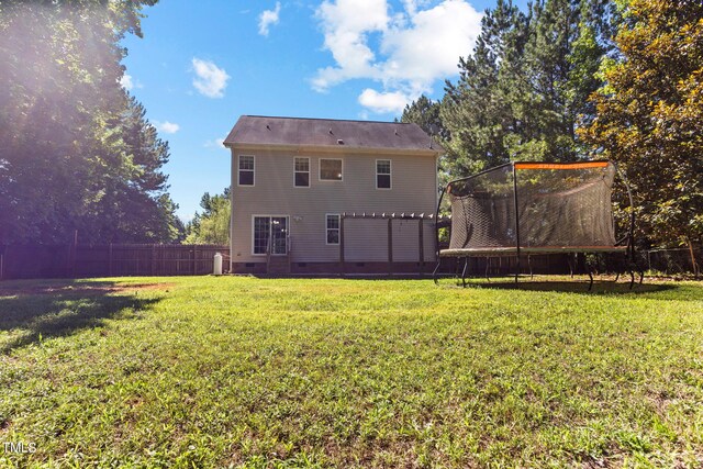 2555 Winding Creek Ln, Franklinton, NC 27525 - back of property featuring crawl space, a trampoline, and a fenced backyard