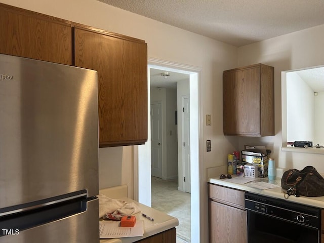 1819 Collier Rd, Durham, NC 27707 - kitchen featuring freestanding refrigerator, black dishwasher, light countertops, a textured ceiling, and brown cabinets
