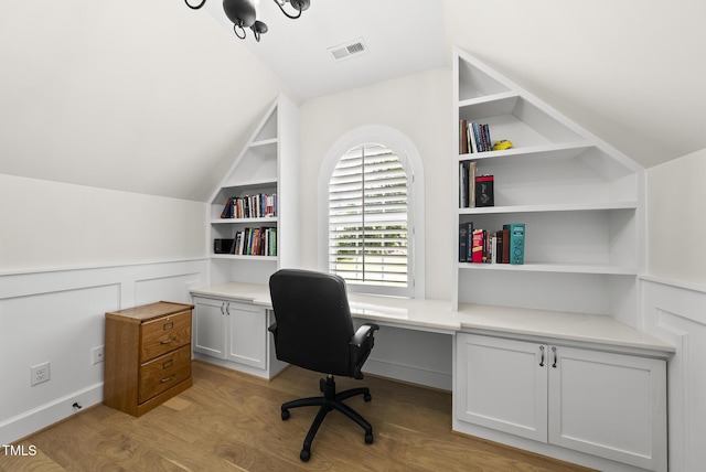 175 Stonecrest Way, Pittsboro, NC 27312 - office area featuring light wood finished floors, lofted ceiling, built in shelves, and a wainscoted wall