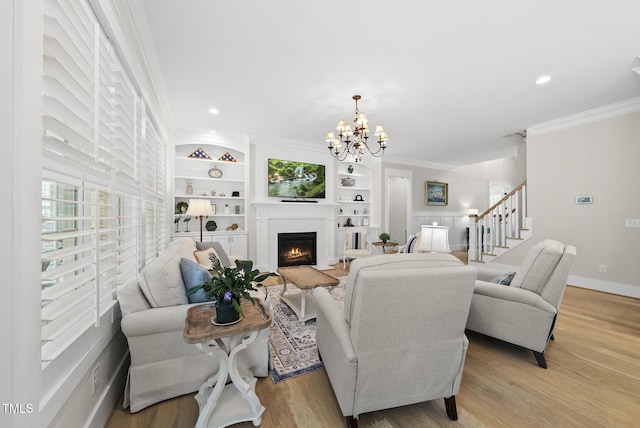 175 Stonecrest Way, Pittsboro, NC 27312 - living area featuring ornamental molding, a chandelier, light wood-type flooring, plenty of natural light, and a lit fireplace