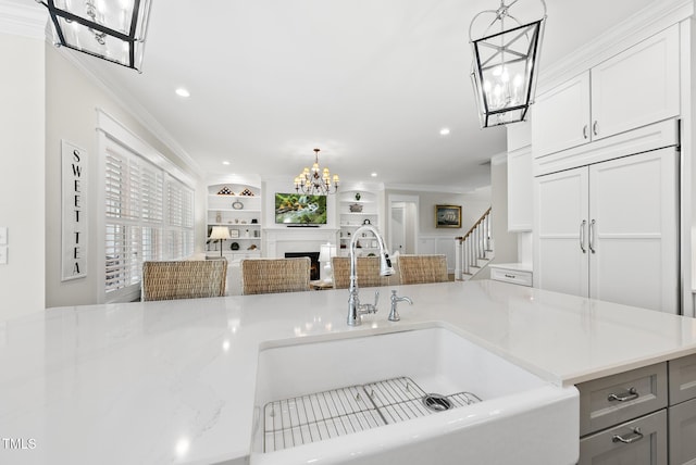 175 Stonecrest Way, Pittsboro, NC 27312 - kitchen with a chandelier, crown molding, open floor plan, white cabinets, and pendant lighting