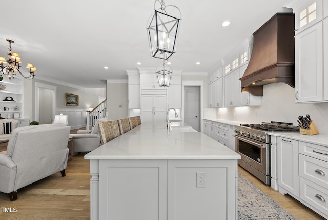 175 Stonecrest Way, Pittsboro, NC 27312 - kitchen with stainless steel stove, premium range hood, a chandelier, crown molding, and open floor plan