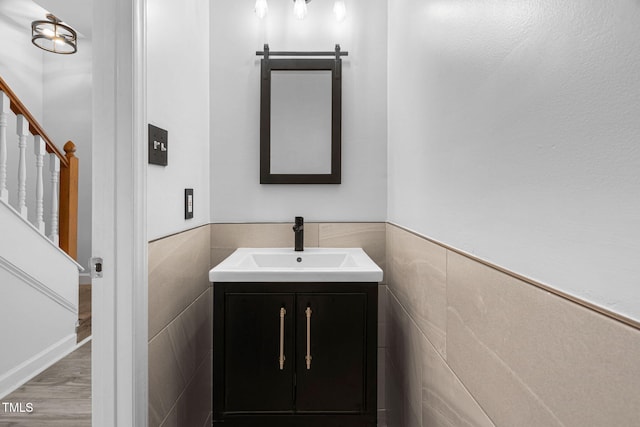 4316 Major Loring Way, Raleigh, NC 27616 - half bathroom with vanity, wood finished floors, tile walls, and wainscoting