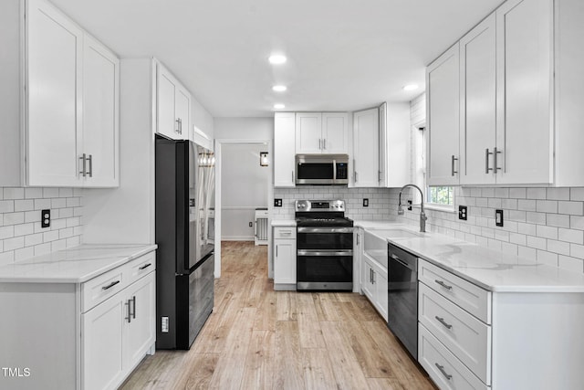 4316 Major Loring Way, Raleigh, NC 27616 - kitchen with stainless steel appliances, recessed lighting, light wood-style flooring, white cabinets, and decorative backsplash