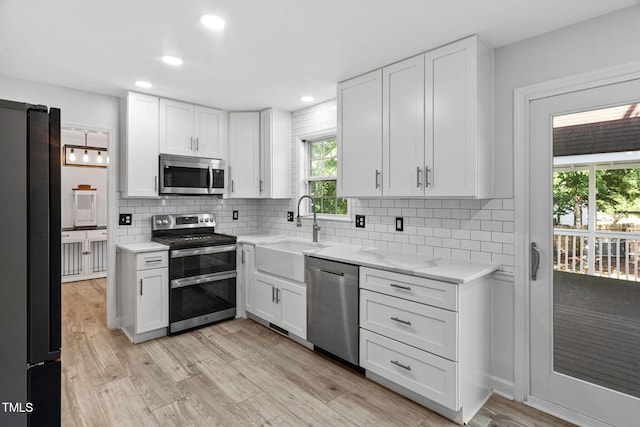 4316 Major Loring Way, Raleigh, NC 27616 - kitchen with stainless steel appliances, white cabinetry, tasteful backsplash, recessed lighting, and light wood-type flooring