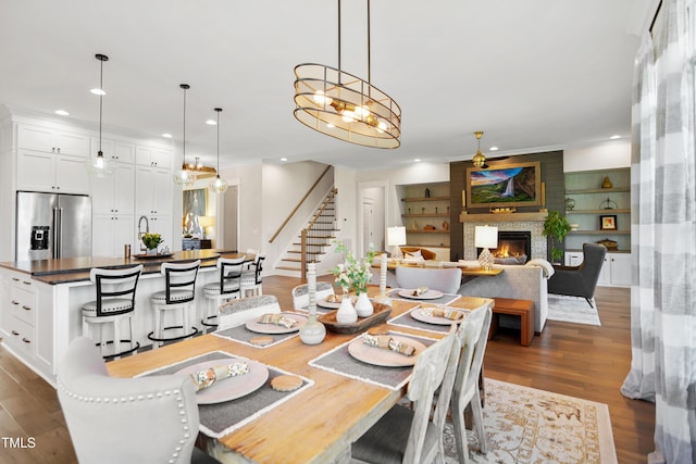 241 Teague St, Wake Forest, NC 27587 - dining space with a fireplace, recessed lighting, wood finished floors, stairs, and a chandelier