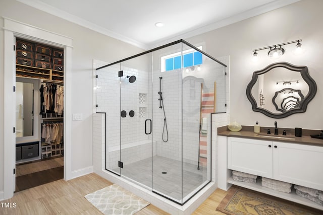 241 Teague St, Wake Forest, NC 27587 - full bathroom featuring wood finished floors, a shower stall, a spacious closet, vanity, and crown molding