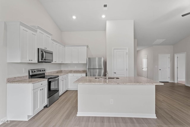 3837 Ava Dr, Bailey, NC 27807 - kitchen featuring stainless steel appliances, a kitchen island with sink, light wood-style flooring, white cabinetry, and light stone counters