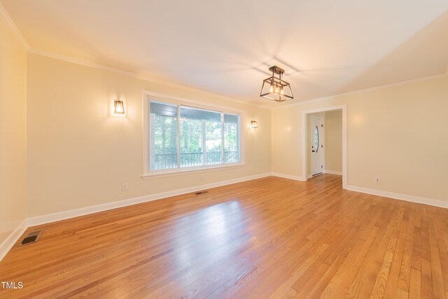 944 Athens Dr, Raleigh, NC 27606 - empty room with a chandelier, ornamental molding, and light wood-style flooring