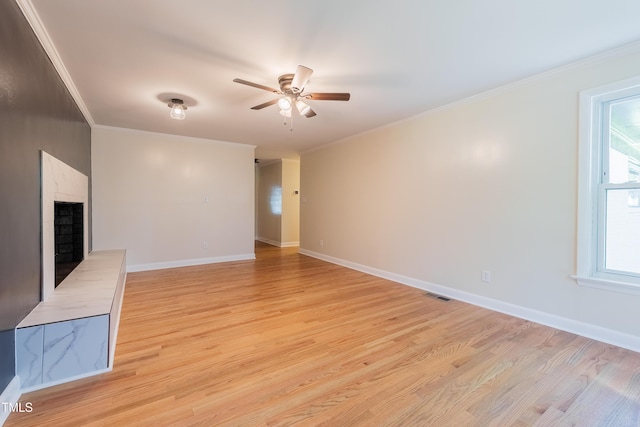 944 Athens Dr, Raleigh, NC 27606 - unfurnished living room with ceiling fan, light wood-style flooring, crown molding, and a fireplace with raised hearth