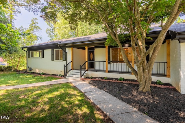 944 Athens Dr, Raleigh, NC 27606 - ranch-style house with brick siding, a porch, and a front yard