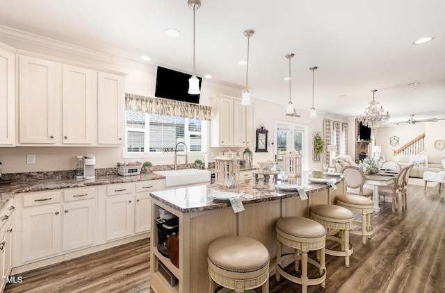 190 Mitchells Chapel Rd, Pittsboro, NC 27312 - kitchen with wood finished floors, a kitchen bar, a center island, light stone countertops, and white cabinets