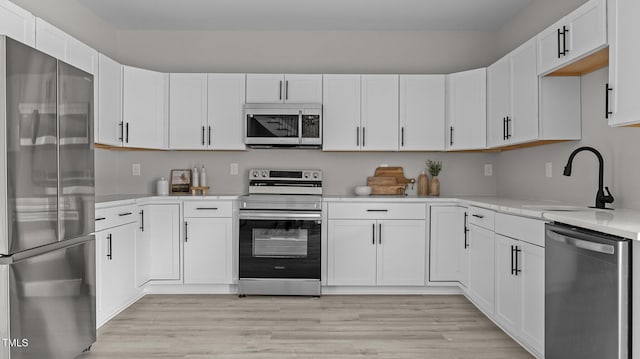 505 Hawfields Rd, Mebane, NC 27302 - kitchen with stainless steel appliances, light countertops, white cabinetry, and light wood-style floors