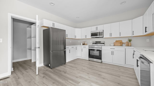 505 Hawfields Rd, Mebane, NC 27302 - kitchen with stainless steel appliances, light countertops, light wood-style floors, white cabinets, and recessed lighting
