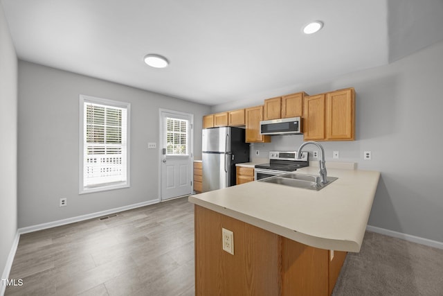 119 Percheron Dr, Zebulon, NC 27597 - kitchen featuring stainless steel appliances, light countertops, a peninsula, a breakfast bar, and light wood-style flooring