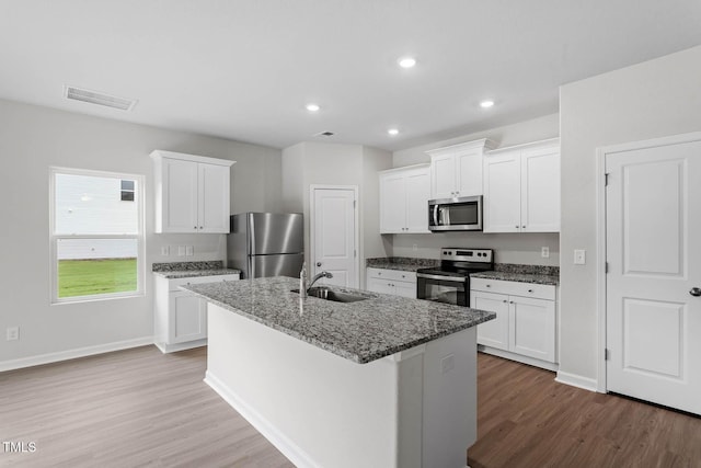3930 Needham Rd, Bailey, NC 27807 - kitchen featuring stainless steel appliances, wood finished floors, a kitchen island with sink, white cabinetry, and recessed lighting