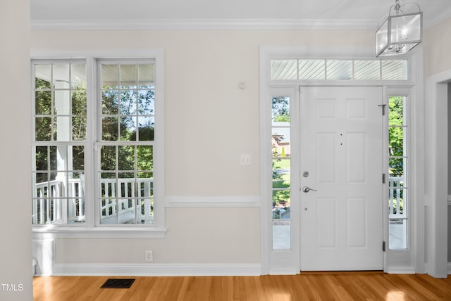 5940 Dahlberg Dr, Raleigh, NC 27603 - foyer entrance with wood finished floors, ornamental molding, healthy amount of natural light, and a chandelier