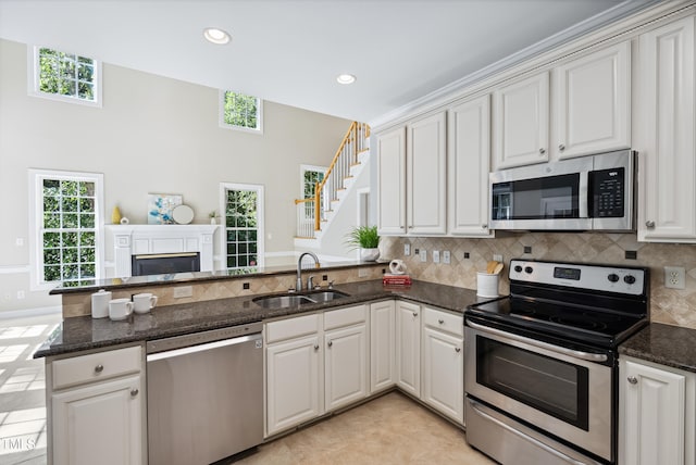 5940 Dahlberg Dr, Raleigh, NC 27603 - kitchen with appliances with stainless steel finishes, a peninsula, plenty of natural light, tasteful backsplash, and recessed lighting