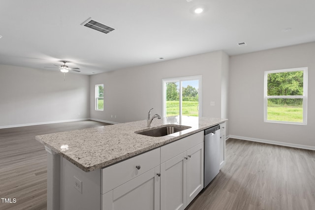 3870 Origin Dr, Bailey, NC 27807 - kitchen featuring stainless steel dishwasher, light wood finished floors, white cabinets, and a center island with sink