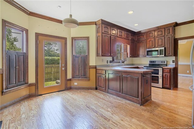 223 Devane St, Fayetteville, NC 28305 - kitchen featuring appliances with stainless steel finishes, a peninsula, light wood-style floors, ornamental molding, and light countertops