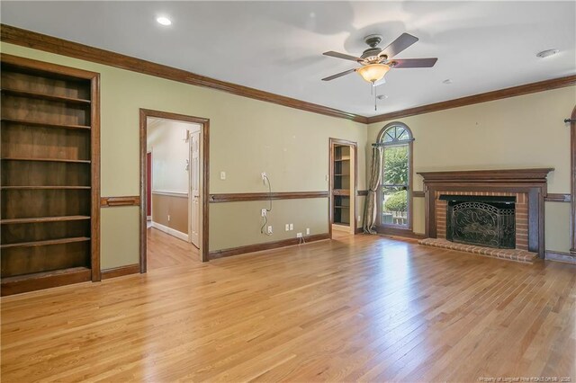 223 Devane St, Fayetteville, NC 28305 - unfurnished living room with light wood-type flooring, a ceiling fan, ornamental molding, and a brick fireplace