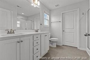 360 Carolina Church Rd, Saint Paul, NC 28384 - bathroom featuring double vanity, a shower with door, and wood finished floors