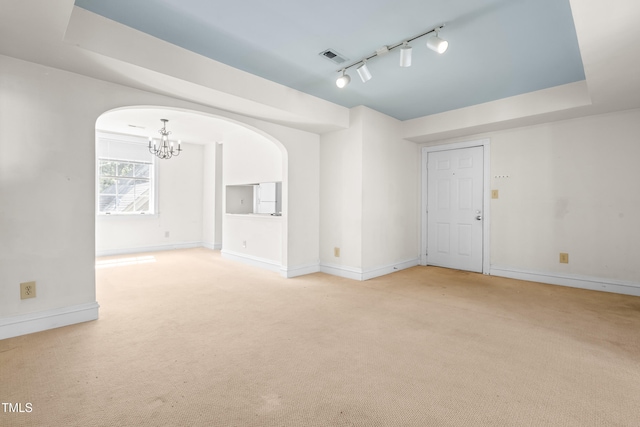 235 Mccauley St Unit # D, Chapel Hill, NC 27516 - spare room with a chandelier, light carpet, arched walkways, rail lighting, and a tray ceiling