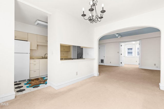 235 Mccauley St Unit # D, Chapel Hill, NC 27516 - unfurnished living room featuring arched walkways, light carpet, and a chandelier