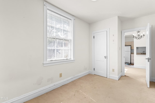 235 Mccauley St Unit # D, Chapel Hill, NC 27516 - unfurnished bedroom with freestanding refrigerator, carpet, and a chandelier