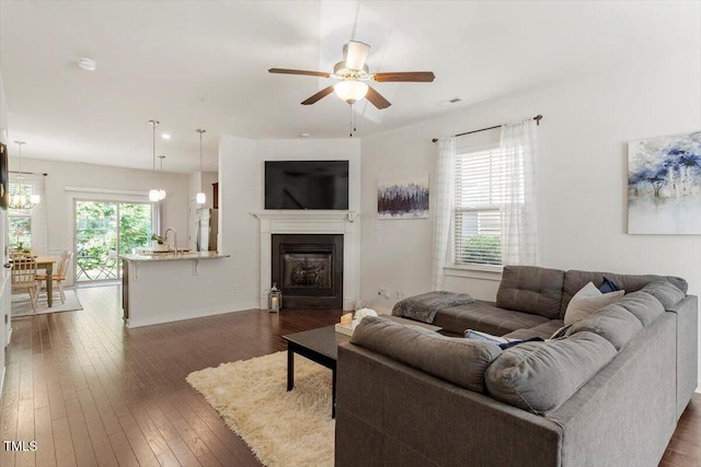 7879 Allscott Way, Raleigh, NC 27612 - living room with dark wood finished floors, ceiling fan, and a glass covered fireplace