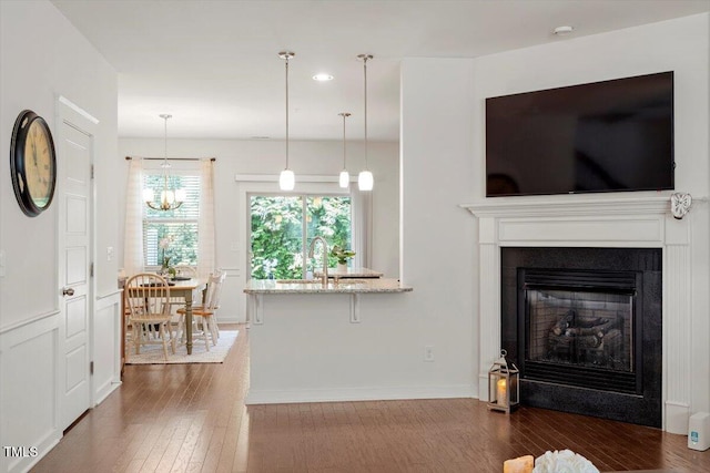 7879 Allscott Way, Raleigh, NC 27612 - living room with dark wood-style floors, a chandelier, recessed lighting, and a glass covered fireplace