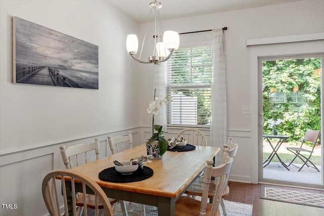 7879 Allscott Way, Raleigh, NC 27612 - dining space with a decorative wall, wood finished floors, a chandelier, and a wainscoted wall