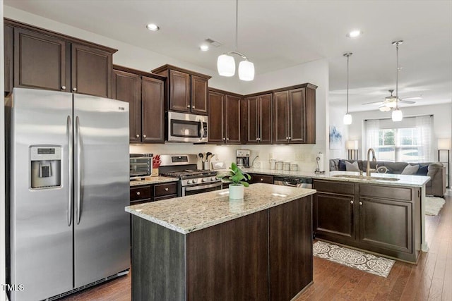 7879 Allscott Way, Raleigh, NC 27612 - kitchen with stainless steel appliances, open floor plan, dark brown cabinets, a peninsula, and light stone countertops