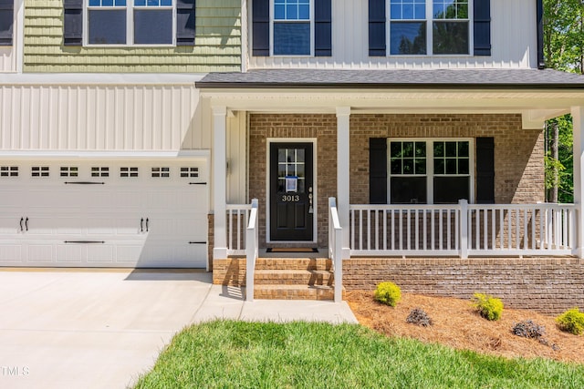 3013 Wesley Farm Ln, Sophia, NC 27350 - property entrance featuring covered porch, brick siding, driveway, board and batten siding, and a garage