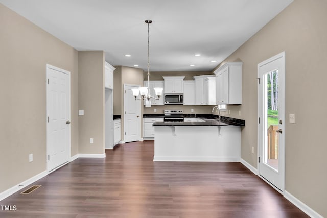 3013 Wesley Farm Ln, Sophia, NC 27350 - kitchen with stainless steel microwave, a peninsula, black range with electric cooktop, dark wood finished floors, and recessed lighting