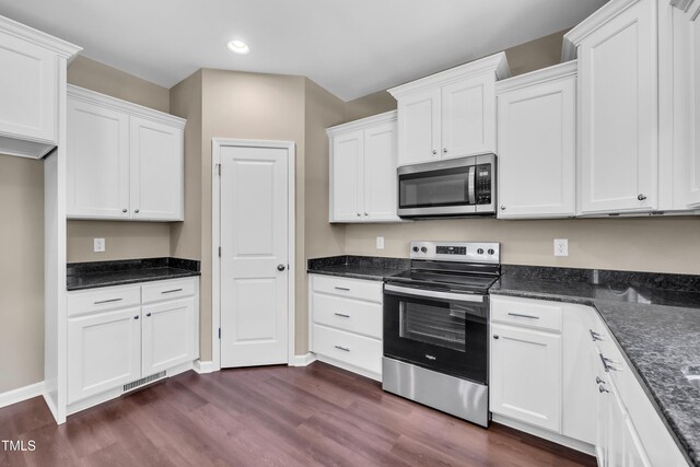 3013 Wesley Farm Ln, Sophia, NC 27350 - kitchen with appliances with stainless steel finishes, dark wood finished floors, white cabinetry, recessed lighting, and dark stone counters
