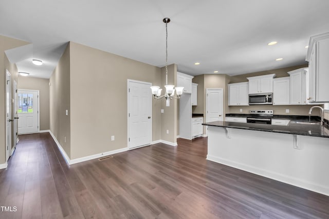 3013 Wesley Farm Ln, Sophia, NC 27350 - kitchen featuring range with electric cooktop, stainless steel microwave, a peninsula, dark wood-style flooring, and white cabinetry