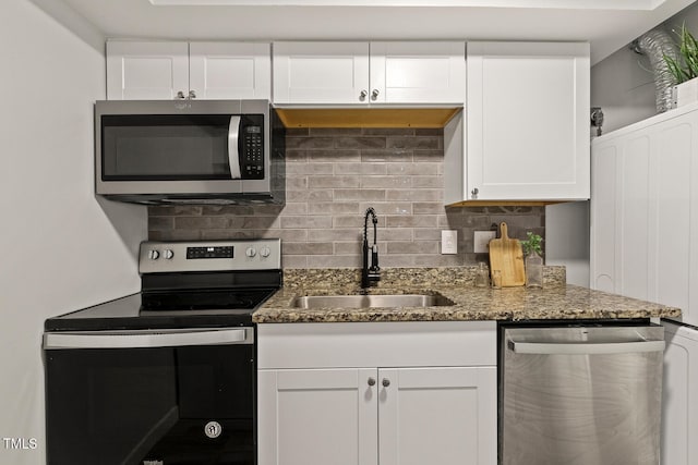 7002 Longstreet Dr Unit C, Raleigh, NC 27615 - kitchen with stainless steel appliances, tasteful backsplash, white cabinets, and dark stone counters