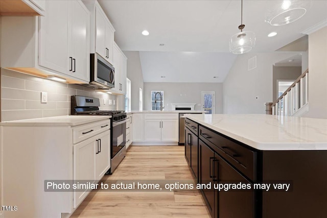 5428 Jaeger Dr Lot # 45, Graham, NC 27253 - kitchen with appliances with stainless steel finishes, light wood-style floors, backsplash, white cabinetry, and light stone countertops