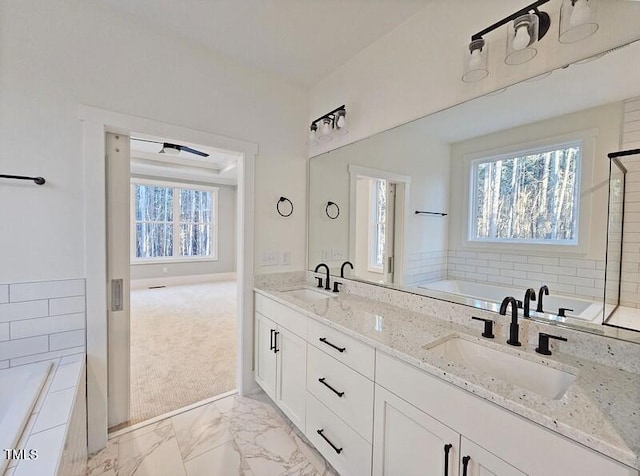5545 Silk Hope Gum Springs Rd, Siler City, NC 27344 - bathroom featuring healthy amount of natural light, a garden tub, marble finish flooring, and double vanity