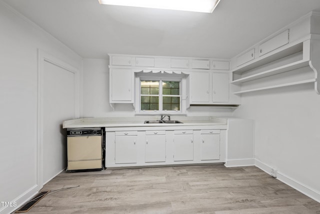 1219 Carlton Ave, Raleigh, NC 27606 - kitchen with white dishwasher, open shelves, light countertops, and white cabinetry