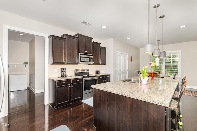 1726 Rapids Ct, Franklinton, NC 27525 - kitchen with appliances with stainless steel finishes, dark wood-type flooring, dark brown cabinets, a kitchen breakfast bar, and light stone counters