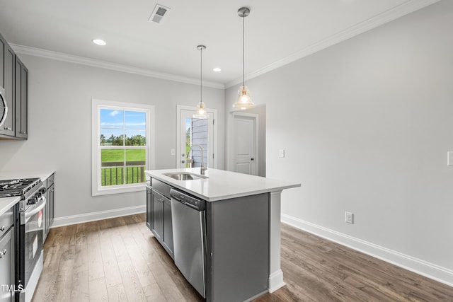 547 Forestville Rd, Wake Forest, NC 27587 - kitchen featuring stainless steel appliances, dark wood-type flooring, light countertops, ornamental molding, and an island with sink