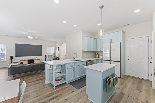 274 Marsh Creek Dr, Garner, NC 27529 - kitchen with freestanding refrigerator, blue cabinetry, open shelves, light countertops, and light wood-style floors