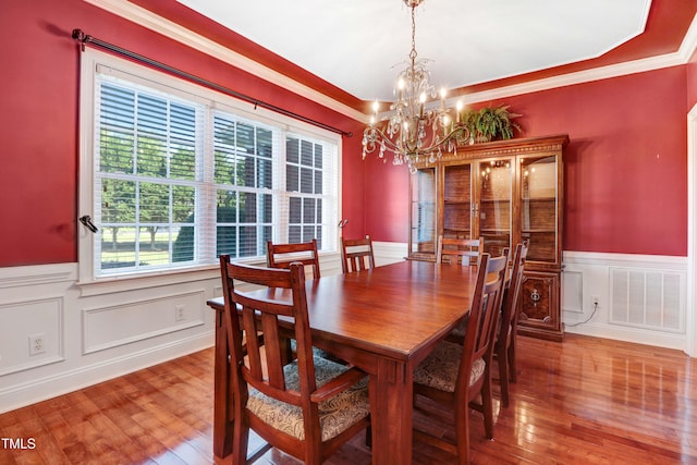 106 Woodmere Ln, Goldsboro, NC 27530 - dining area featuring a chandelier, wainscoting, hardwood / wood-style floors, crown molding, and a decorative wall