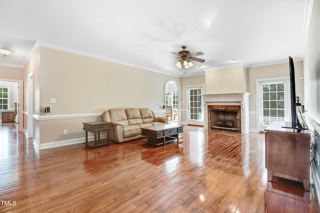 106 Woodmere Ln, Goldsboro, NC 27530 - living room featuring light wood-style floors, ceiling fan, a high end fireplace, arched walkways, and crown molding
