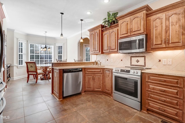 106 Woodmere Ln, Goldsboro, NC 27530 - kitchen with appliances with stainless steel finishes, crown molding, arched walkways, a chandelier, and tasteful backsplash