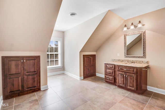 106 Woodmere Ln, Goldsboro, NC 27530 - bathroom featuring vanity, vaulted ceiling, and tile patterned flooring