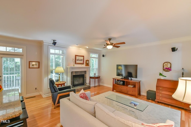 119 Jones Creek Pl Unit 119, Chapel Hill, NC 27516 - living area featuring a tiled fireplace, light wood-style flooring, ornamental molding, and a ceiling fan